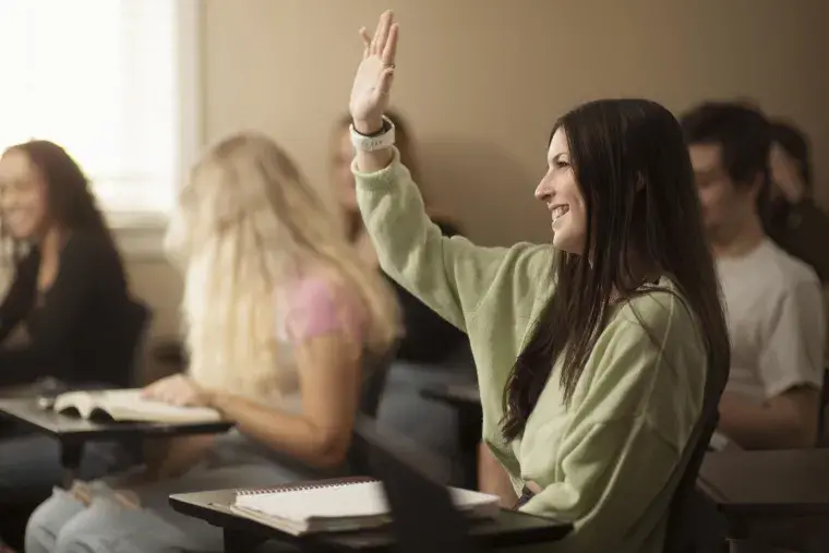 A Flagler College student raises her hand.