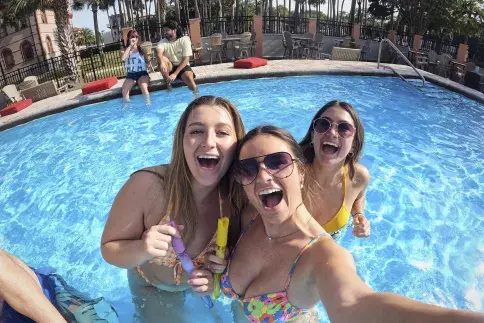 Three students smile in one of two pools on Flagler campus.