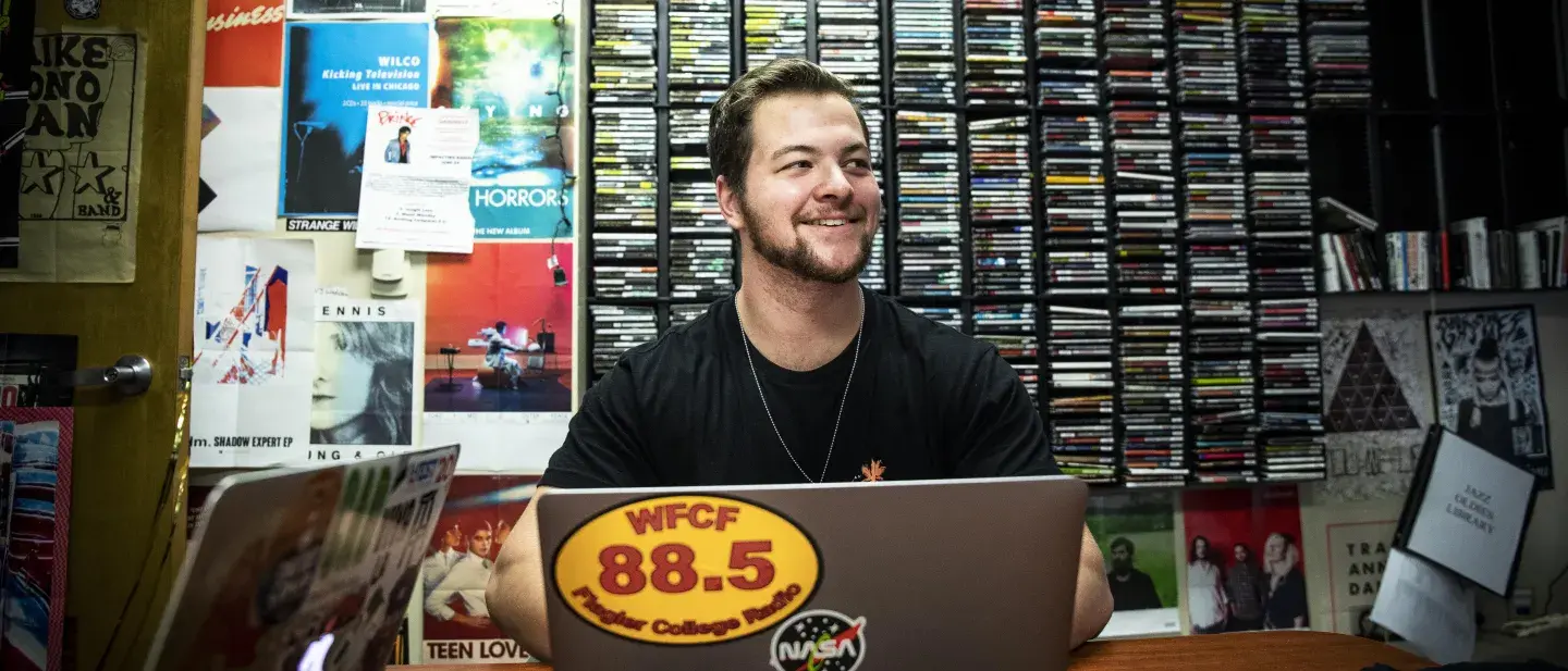 A Flagler College student works in the Flagler College radio station offices.