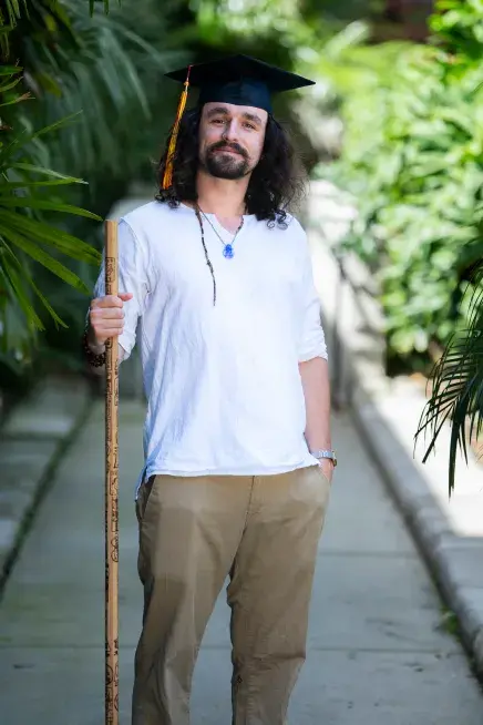 Jake Van Clief standing on a path holding a walking stick