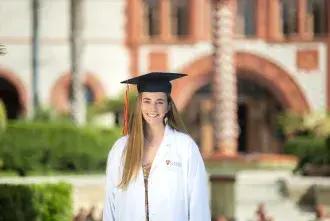 Carly Shaw in lab coat posed in Ponce courtyard