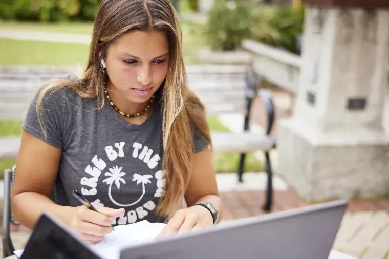 A Flagler College student completes classwork on a laptop.