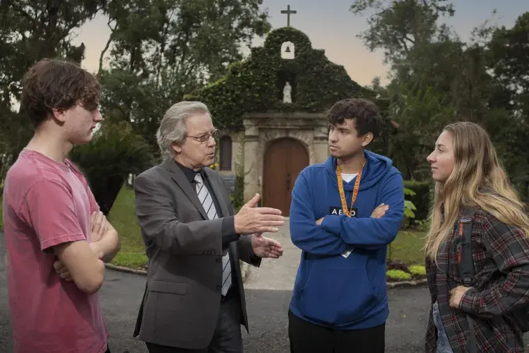 A faculty member talks to students at a shrine in downtown St. Augustine.