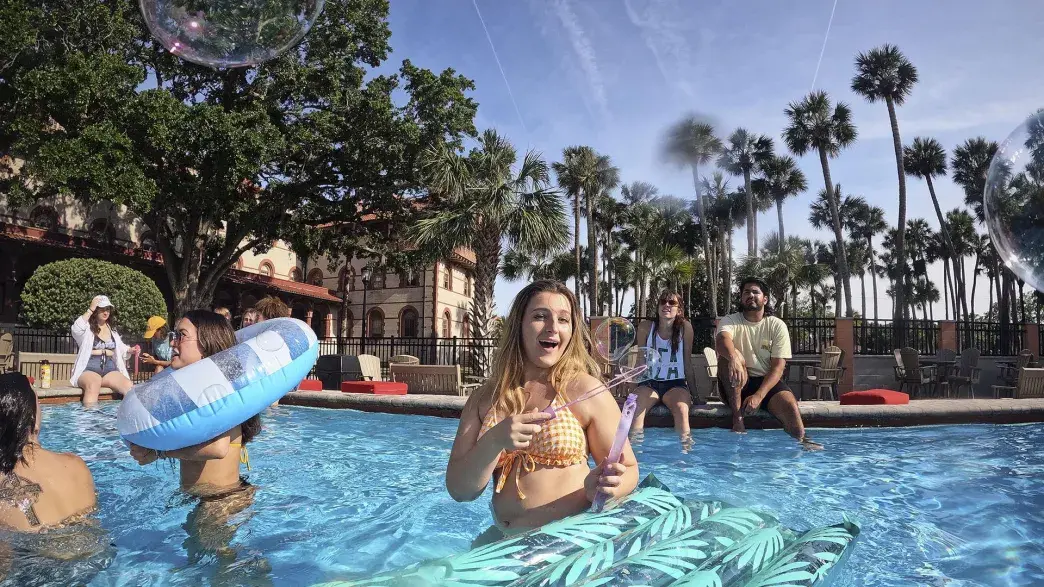 Students playing at the pool on a sunny day