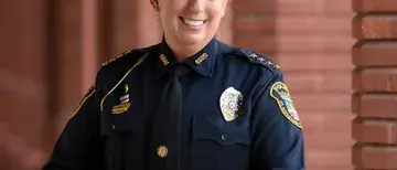 In uniform, Jennifer Michaux, Chief of Police for the city of St. Augustine, poses near the Ponce Hall pillars