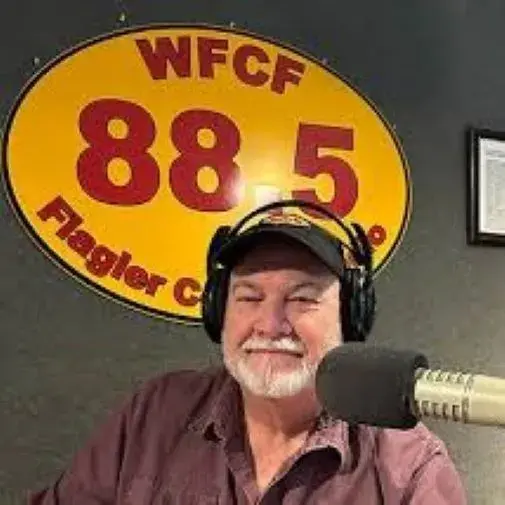 Dan McCook sitting in front of a microphone at the WFCF Radio Station