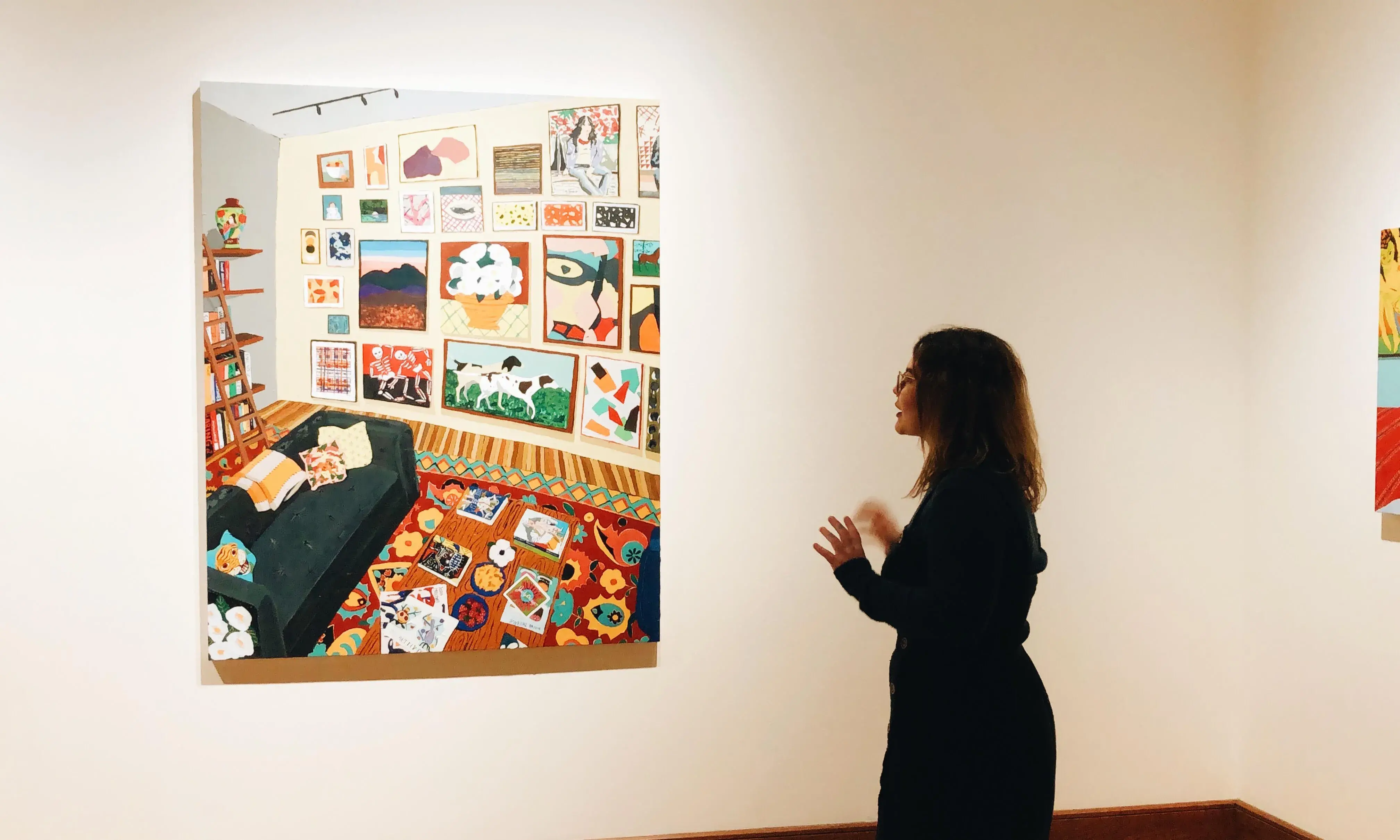 A faculty member examines hanging art work.