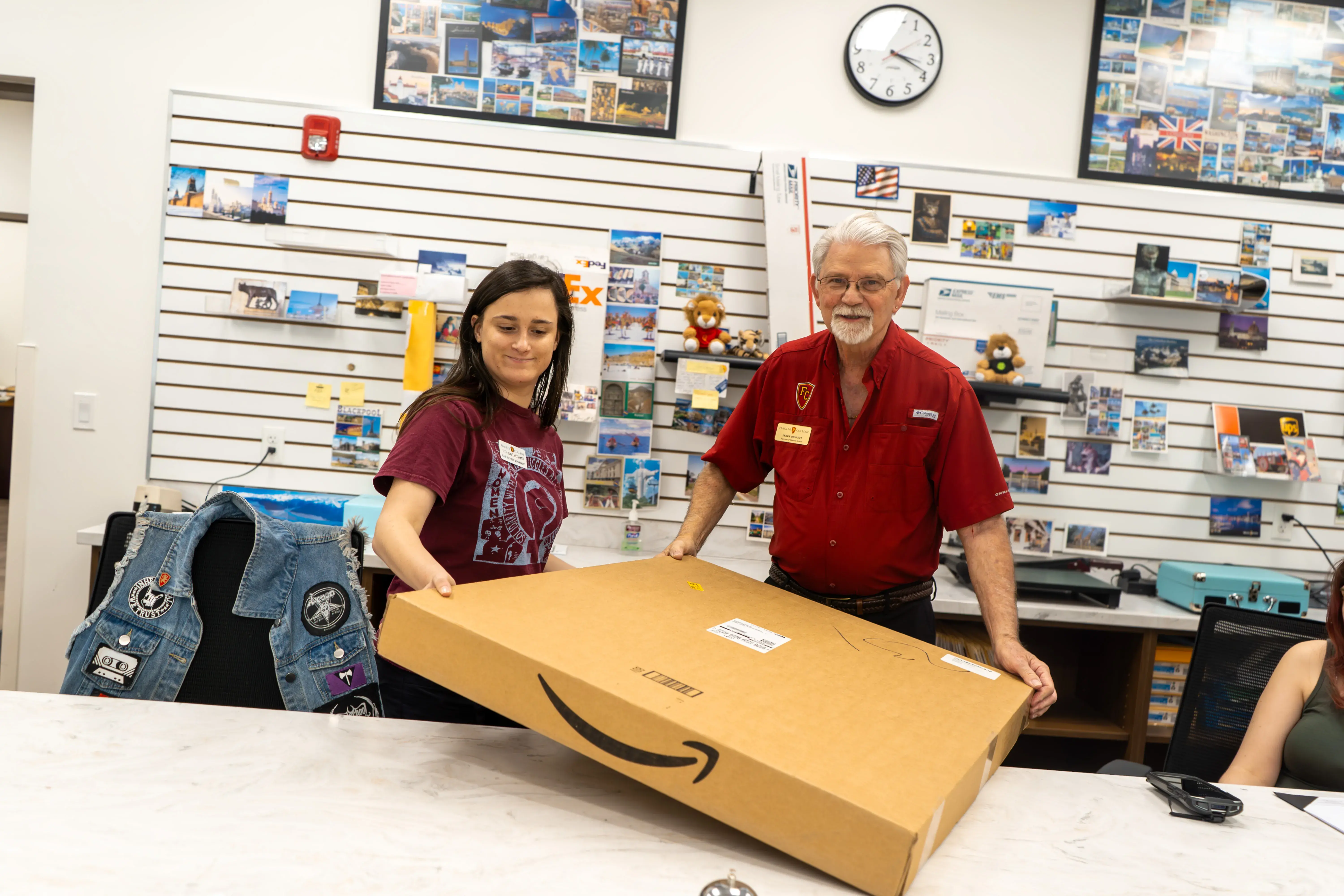 Bennett helping current mailroom student worker at front counter