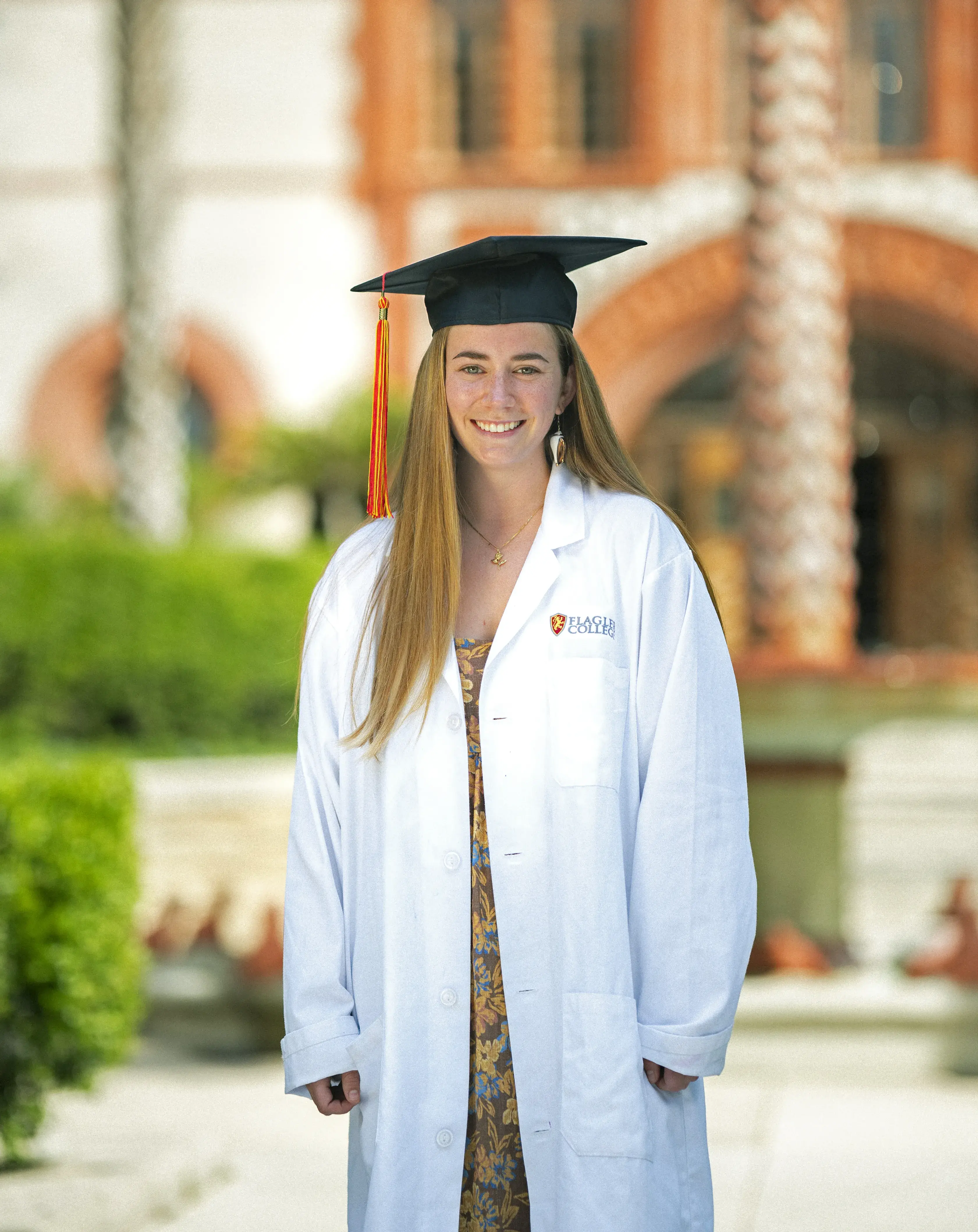 Shaw in lab coat in front of fountain